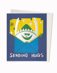 Sending Hugs Greeting Card is a silver foil hug appearing from an envelope featuring artwork by artist and screen printer, David Newton.